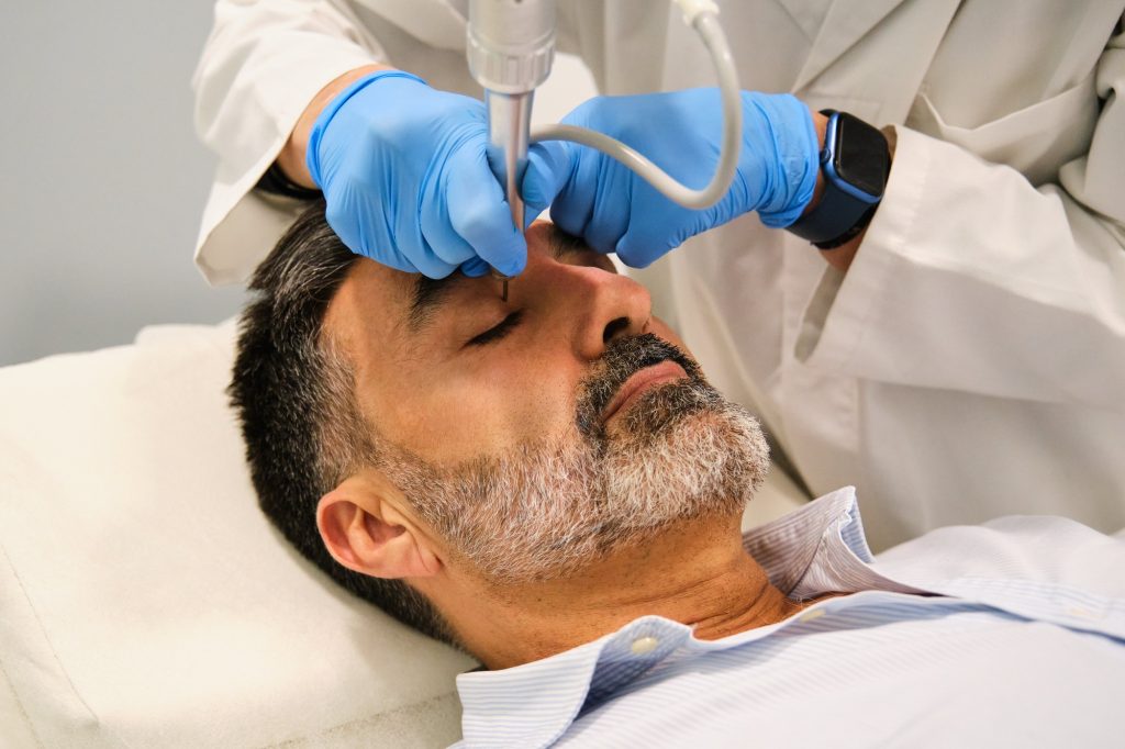 A man is getting a Non-Surgical Eyelid Lift or blepharoplasty.