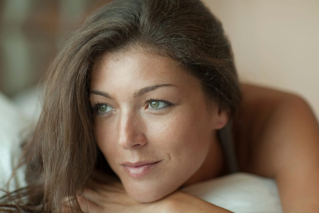 Thoughtful woman lying down with a gentle gaze